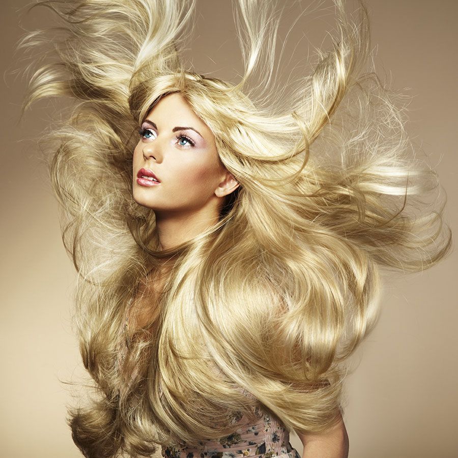 Frau mit langen blonden Haaren die im Winde wehen.